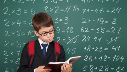 School boy exercise math on board