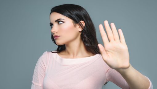 Beautiful girl with bad mood gesturing stop symbol